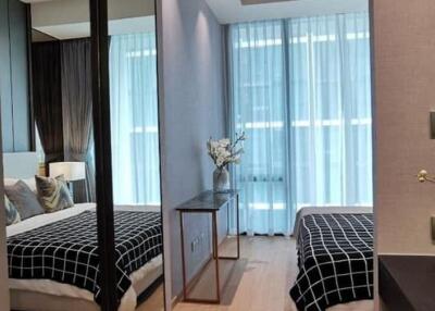 Modern bedroom with a large mirror, bed, and a console table with decorative items