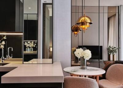 Modern living area with kitchen island, decorative lighting, and stylish furnishings