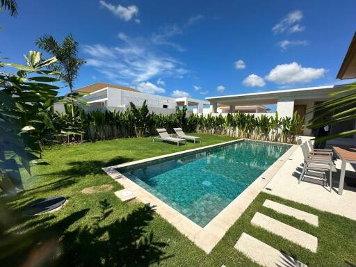 Beautiful outdoor pool area with lounge chairs and lush greenery