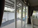 Living room with large glass doors leading to a backyard with gravel and a slide