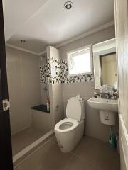 Modern bathroom with toilet, sink, and shower area