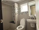 Modern bathroom with toilet, sink, and shower area