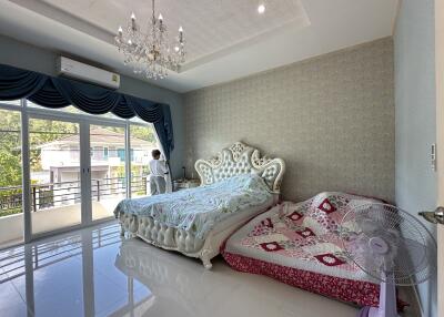 Spacious bedroom with chandelier and large windows