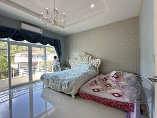 Spacious bedroom with chandelier and large windows