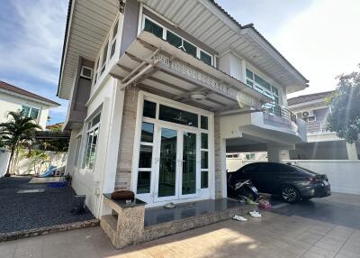 Front view of a modern two-story house with a driveway and carport