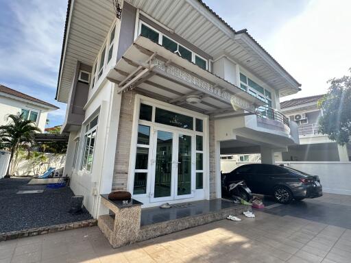 Front view of a modern two-story house with a driveway and carport