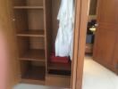 Open wardrobe with shelves and hanging bathrobes in a bedroom