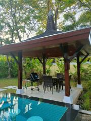 Covered outdoor dining area with pool