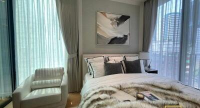 Modern bedroom with a large window, stylish decor, and comfortable furnishings