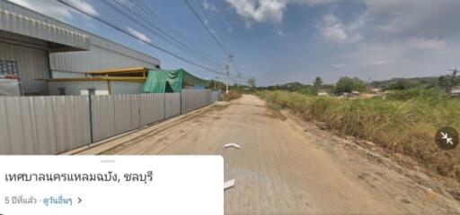 Rural street view with industrial building and open land