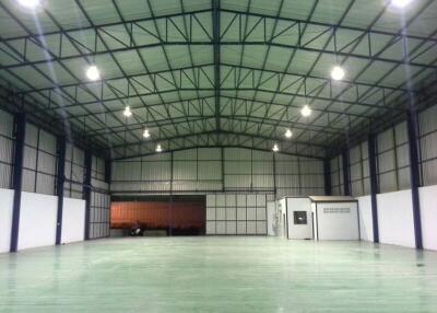 Spacious empty industrial warehouse with high ceiling and multiple light fixtures