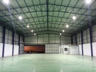 Spacious empty industrial warehouse with high ceiling and multiple light fixtures