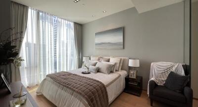 Modern bedroom with large window, double bed, wall art, and cozy armchair