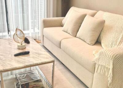 Cozy living room with beige sofa and glass coffee table
