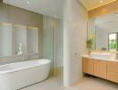 Modern bathroom with bathtub, glass shower, and double sink vanity