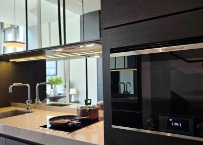 Modern kitchen with black cabinetry, built-in appliances, and a sleek countertop