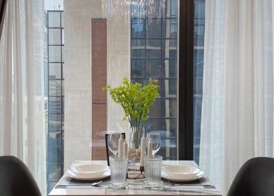 Dining table set by a window with city view