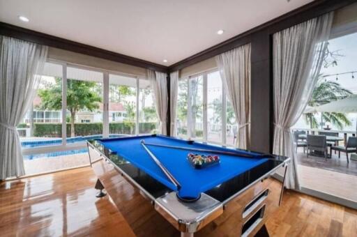 Room with large windows, pool table, and view of a pool and patio