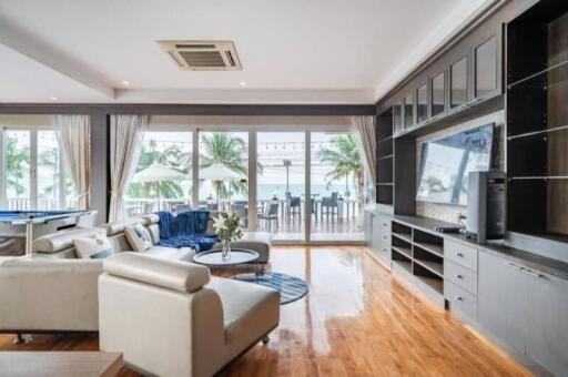 Spacious living room with modern furniture, large windows, and built-in shelving