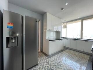 Modern kitchen with stainless steel appliances and patterned tile flooring