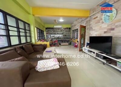 Spacious living room with brown sectional sofa, TV, and a wall clock