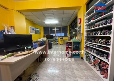Office space with bright yellow walls and shelves filled with collectibles