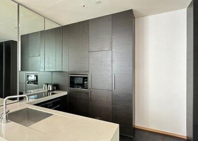 Modern kitchen with built-in appliances and mirrored backsplash