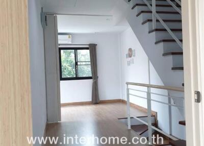 Main living space with staircase and wooden flooring