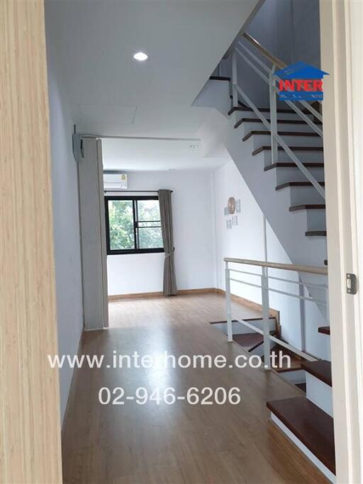 Main living space with staircase and wooden flooring