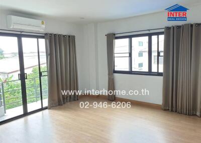 Spacious living room with large windows and balcony access