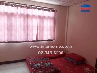 Simple bedroom with mattress on the floor and pink curtains