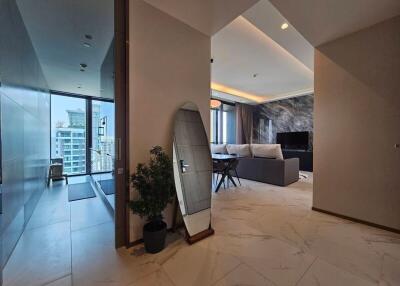 Main living area with reflective surfaces, modern furnishings, and city view
