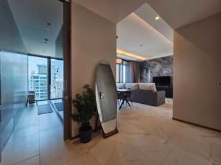 Main living area with reflective surfaces, modern furnishings, and city view