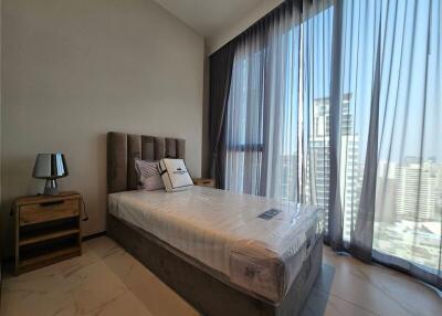 Well-lit bedroom with floor-to-ceiling windows