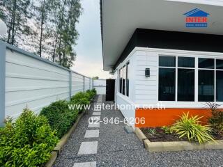 Exterior of a residential property with a garden walkway and large windows