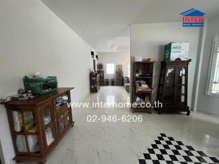 Spacious living area with decorative wooden cabinets and tiled flooring