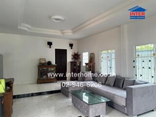 Spacious living room with grey L-shaped sofa and glass coffee table