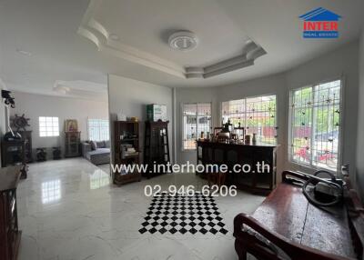 Spacious living room with classic furniture and large windows allowing ample natural light