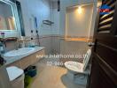 Bathroom with a sink, toilet, wall mirror, and storage rack.