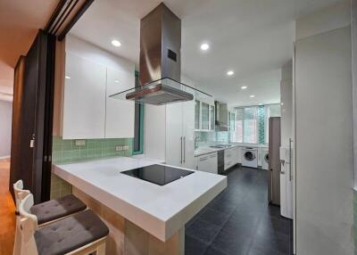 Modern kitchen with island, hood, and built-in appliances