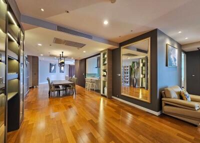 Spacious modern living area with wooden floors, large mirror, and contemporary furniture