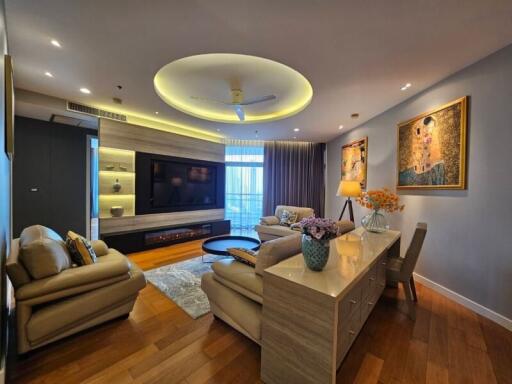 Modern living room with ceiling lighting, wall-mounted TV, and comfortable seating