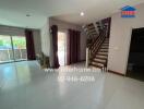 Spacious living area with natural light and modern staircase