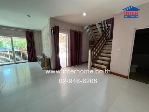 Spacious living area with natural light and modern staircase