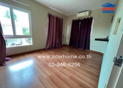 Bedroom with wooden flooring and purple curtains