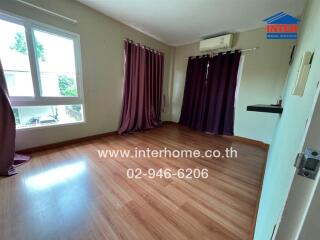 Bedroom with wooden flooring and purple curtains