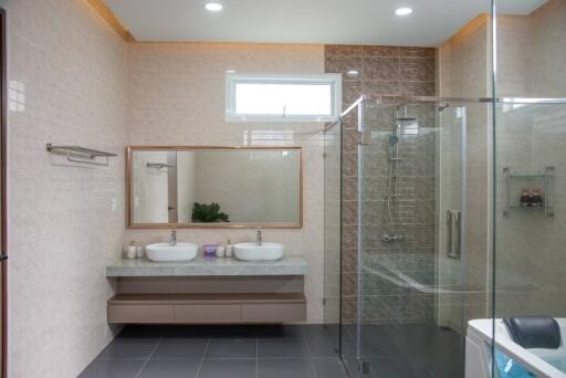 Modern bathroom with double sinks and glass shower enclosure