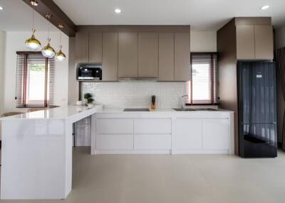Modern kitchen with sleek cabinets, large counter space, and contemporary light fixtures