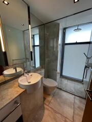 Modern bathroom with glass shower, marble countertops, and large mirror