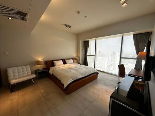 Spacious bedroom with large windows and city view